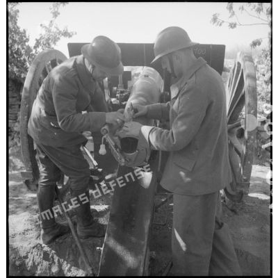 Deux artilleurs mesurent l'angle de pointage de leur canon de 75 mm modèle 1897.