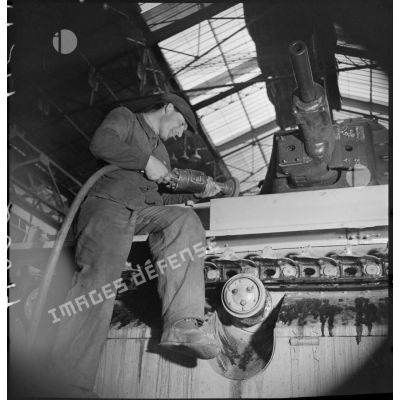 A l'atelier d'Issy-les-Moulineaux un ouvrier ponce la caisse d'un char Renault R40.