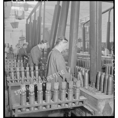 Des ouvriers confectionnent des obus.
