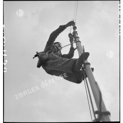 Un élève apprenti de Sevran est photographié en contre-plongée en haut d'un poteau électrique.