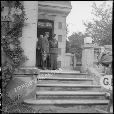 Des officiers britanniques de la BEF se tiennent à l'entrée d'une maison.