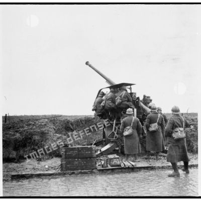 Plan général d'un canon de 75 mm CA M17/34 photographié de trois quarts arrière et de ses servants en poste.