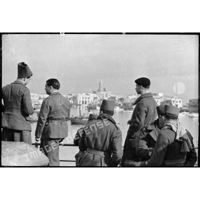 A bord du "Ville d'Alger" des tirailleurs algériens regardent s'éloigner le port d'Alger.