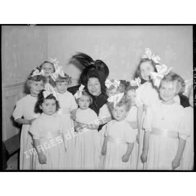 La directrice du théâtre Antoine, à Paris, entourée de petites orphelines.