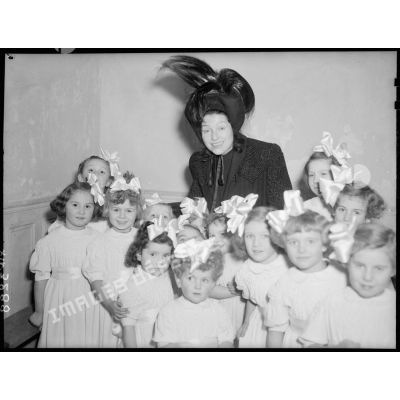 La directrice du théâtre Antoine, à Paris, entourée de petites orphelines.