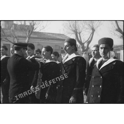 Un maître inspecte les tenues de marins algériens, dits Baharia, alignés sur les rangs.