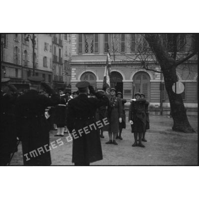 Des amiraux saluent le drapeau d'une unité de l'armée de Terre lors de l'exécution de la Marseillaise au cours d'une prise d'armes.