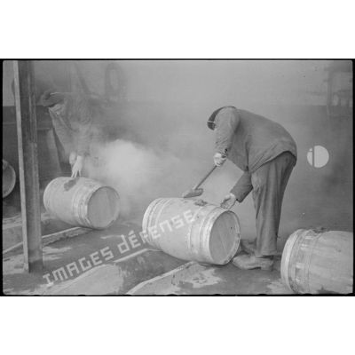 Des marins fabriquent des tonneaux à la section des liquides de l'arsenal de Brest.