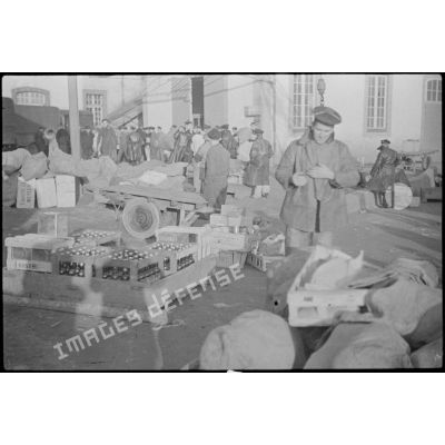 Marchandises et vivres stockés sur un quai devant les subsistances de la Marine.