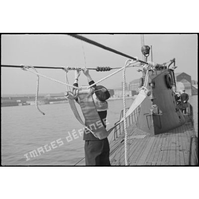 Un marin est installé dans le "siège" du commandant sur le pont du sous-marin Orphée.