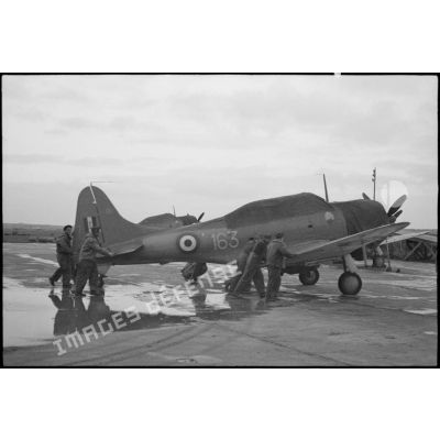 Un bombardier en piqué Douglas SBD-5 Dauntless de la flottille 4FB de l'aéronautique navale est poussé sur une piste d'envol sur la base de Cognac.