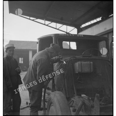Des soudeurs allemands rénovent un véhicule français, dans les ateliers des Issers.