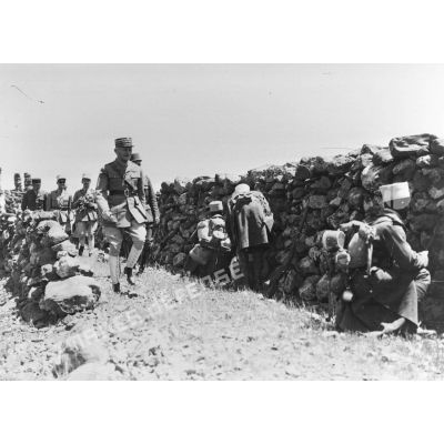 Le général d'armée Weygand marche vers l'objectif tout en logeant sur la gauche un mur de pierres sèches près duquel se trouve des tirailleurs sénégalais du 17e RTS postés.