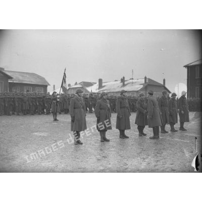 Le général de brigade De Lattre, commandant la 14e DI de la 4e armée, serre la main de récipiendaires du 152e RI lors d'une remise de décorations.