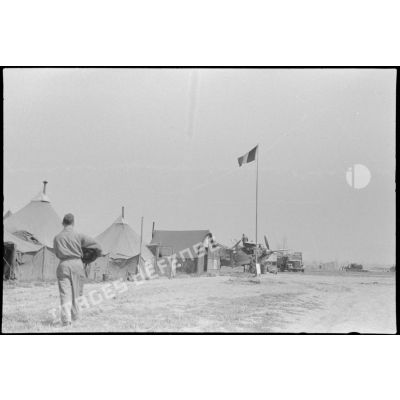 Le campement à côté du terrain d'aviation, un photographe se dirige vers un avion.