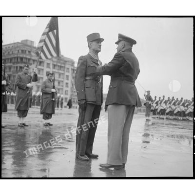 Au cours d'une prise d'armes franco-américaine sur le Forum d'Alger, un général de brigade est décoré par un général américain de la croix de commandeur de l'ordre de la Legion of merit.