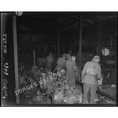 Des prisonniers de guerre allemands démontent et lavent des moteurs, dans les ateliers fixes des Issers.