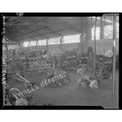 Des prisonniers de guerre allemands examinent avec soin des essieux et des transmissions, dans les ateliers fixes des Issers.