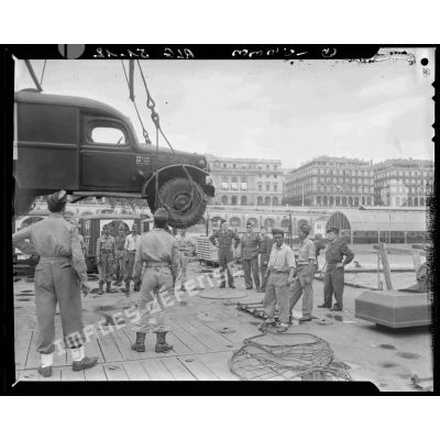 Déchargement d'un véhicule militaire d'un LSt (Landing Ship Tank) sur le port d'Alger par la Marine Nationale.