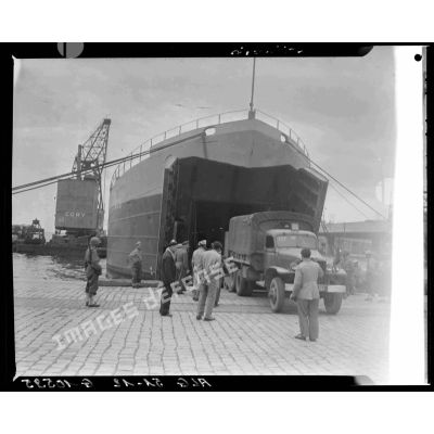 Déchargement de camions militaires depuis un LST (Landing Ship Tank) sur le port d'Alger.
