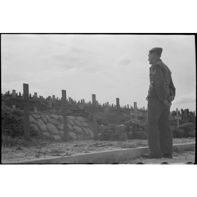 Au cimetière de Maleme (Crète), un caporal de la Luftwaffe se recueille devant des tombes de parachutistes allemandes tombés lors de l'opération Merkur.