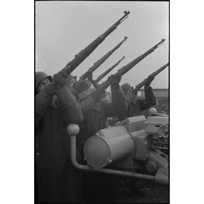 Au sein d'une batterie de 8,8 cm FlaK, les servants d'un télémètre (Kommandogerät 36) apportent leur appui feu à l'aide de fusil Mauser 98k.