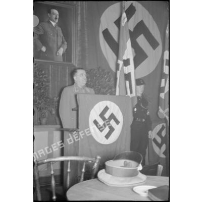 Discours d'un Gauleiter devant une peinture d'Adolf Hitler.