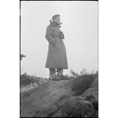 Un soldat de l'artillerie de marine scrute l'horizon dans son poste d'observation côtier.