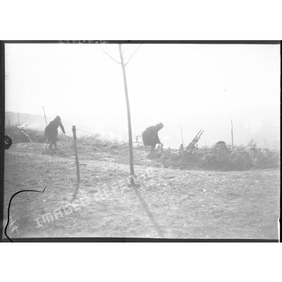 Deux soldats rejoignent un emplacement de mitrailleuses Hotchkiss modèle 1914 jumelées.