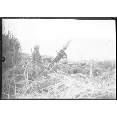 Des soldats servent des mitrailleuses Hotchkiss modèle 1914 jumelées sur affût double de marine.