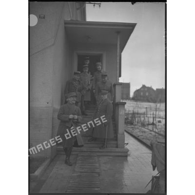 Photographie de groupe d'officiers français et du général d'armée Réquin sur le perron d'une maison.