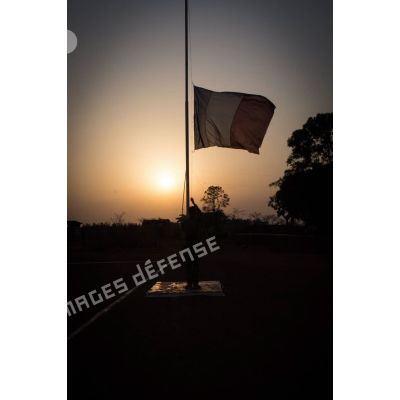 Tirailleur du GTIA (groupement tactique interarmes) Turco abaissant le drapeau lors de la cérémonie aux couleurs sur la place d'armes de la POD (plateforme opérationnelle défense) de Bambari, au soir du 13 mars 2015.