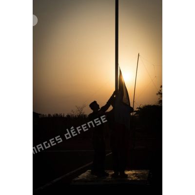 Tirailleurs du GTIA (groupement tactique interarmes) Turco abaissant le drapeau lors de la cérémonie aux couleurs sur la place d'armes de la POD (plateforme opérationnelle défense) de Bambari, au soir du 13 mars 2015.