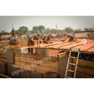 Soldats du 3e RG consolidant la toiture d'un bâtiment lors d'une intervention auprès du GTIA (groupement tactique interarmes) Turco, afin de procéder aux réparations des installations de l'aérodrome de Bambari détruites suite au passage d'une tempête.