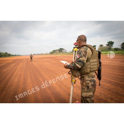 Soldats du 25e RGA du détachement logistique du GTIA (groupement tactique interarmes) Turco, mesurant au moyen d'un théodolite et d'une mire topographique le niveau du sol de la piste de l'aérodrome de la POD (plateforme opérationnelle défense) de Bambari, lors des travaux d'entretien à effectuer.