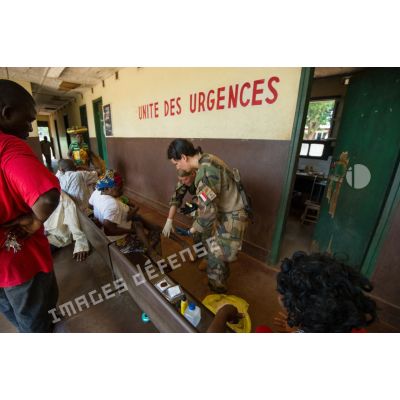 Une infirmière du rôle 1 de la POD (plateforme opérationnelle défense) de Bambari, accompagnée d'une auxiliaire de santé, applique un pansement contre les morsures animales aux urgences de l'hôpital régional universitaire de la ville, dans le cadre d'une AMP (aide médicale à la population).
