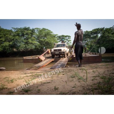 Eléments des forces armées de la MINUSCA (mission multidimensionnelle intégrée des Nations Unies pour la stabilisation en Centrafrique) à bord d'un pick-up Toyota, débarquant du bac de Gimbissi sur la rivière Baibou pour se rendre sur le site d'un charnier identifié dans la zone.