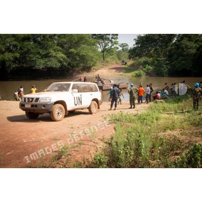 Une Nissan 4x4 siglée "UN" stationne sur les berges de la rivière Baibou, lors de la traversée de casques bleus de la MINUSCA (mission multidimensionnelle intégrée des Nations Unies pour la stabilisation en Centrafrique) par le bac de Gimbissi pour se rendre sur le site d'un charnier identifié dans la zone.