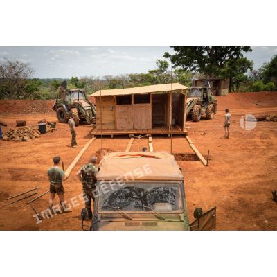 Soldats du groupe d'appui du Génie du GTIA (groupement tactique interarmes) Turco s'apprêtant à déplacer un module sanitaire afin de le transporter d'une fosse septique à une autre, dans le cadre du réaménagement des installations sanitaires de la POD (plateforme opérationnelle défense) de Bambari.