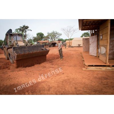 Une tractopelle EGRAP (engin du génie rapide de protection) utilisée par les soldats du groupe d'appui du Génie du GTIA (groupement tactique interarmes) aplanit le sol recouvrant une ancienne fosse septique, dans le cadre du réaménagement des installations sanitaires de la POD (plateforme opérationnelle défense) de Bambari.