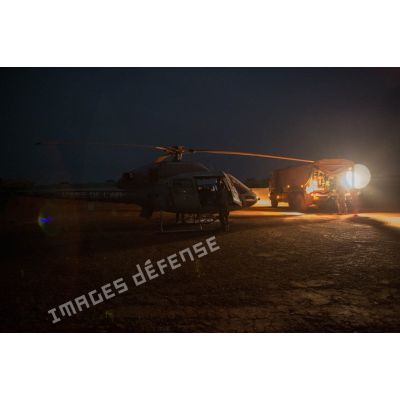 Ravitaillement de nuit d'un hélicoptère AS-550 Fennec du DETFENNEC (détachement d'hélicoptères Fennec) de l'armée de l'Air sur l'aérodrome de la POD (plateforme opérationnelle défense) de Bambari, au moyen d'un camion-citerne Scania CCP 10 (camion-citerne polyvalent de 10 mètres cube) du détachement opérationnel du SEA (Service des essences des armées) du GTIA (groupement tactique interarmes) Turco.