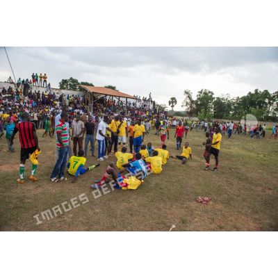 Joueurs de football se reposant en mi-temps sous le regard du public au cours d'une manifestation sportive pour la paix au stade de Bambari, lors de la journée internationale de la jeunesse.