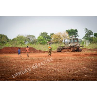 Habitants des environs de Makangé ramassant le petit bois d'une zone déboisée par un bulldozer Liebherr de type PR 724 LGP du 25e RGA en prévision de la réalisation d'un terrain de football.