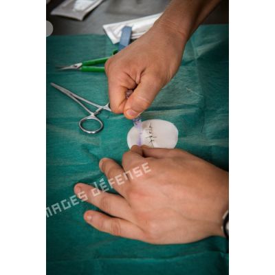 Dans l'enceinte du rôle 1 de la POD (plateforme opérationnelle défense) de Bambari, les membres détachement médical attaché au GTIA (groupement tactique interarmes) Turco suivent un cours de révision des techniques de sutures.