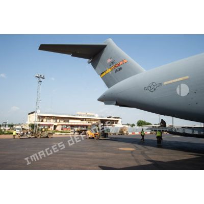 Des éléments du 1er RTP affecté au DéTIA (détachement de transit interarmées) procèdent au chargement de fret dans la soute d'un avion Douglas C-17 de l'US Air Force stationnant sur le tarmac de l'aéroport M'Poko de Bangui au moyen d'un chariot élévateur OMG Ergos 80 HYD, dans le cadre du désengagement progressif de la force Sangaris.