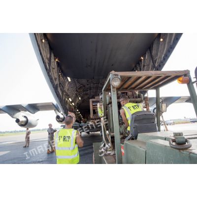 Des éléments du 1er RTP affecté au DéTIA (détachement de transit interarmées) procèdent au chargement de fret dans la soute d'un avion Douglas C-17 de l'US Air Force stationnant sur le tarmac de l'aéroport M'Poko de Bangui, dans le cadre du désengagement progressif de la force Sangaris.
