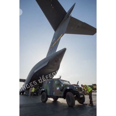 Des éléments du 1er RTP affecté au DéTIA (détachement de transit interarmées) procèdent au chargement de véhicules PVP (petit véhicule protégé) dans la soute d'un avion Douglas C-17 de l'US Air Force stationnant sur le tarmac de l'aéroport M'Poko de Bangui, dans le cadre du désengagement progressif de la force Sangaris.