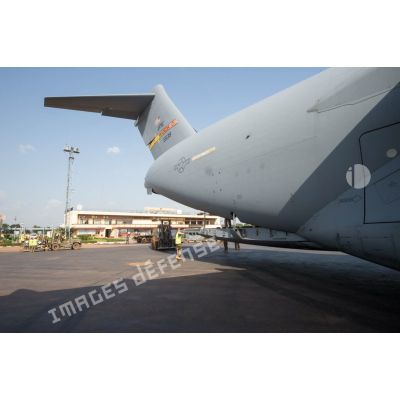 Des éléments du 1er RTP affecté au DéTIA (détachement de transit interarmées) procèdent au chargement de fret dans la soute d'un avion Douglas C-17 de l'US Air Force stationnant sur le tarmac de l'aéroport M'Poko de Bangui au moyen d'un chariot élévateur OMG Ergos 80 HYD, dans le cadre du désengagement progressif de la force Sangaris.