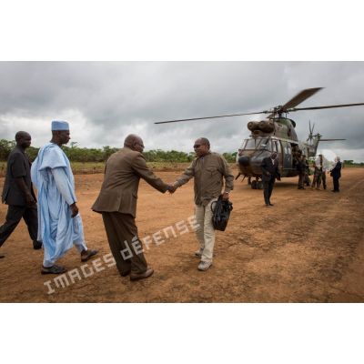 Monsieur Jean-Jacques Démafouth, conseiller auprès de la Présidence de la République centrafricaine, est accueilli par les autorités locales, lors de son arrivée avec la délégation franco-centrafricaine par hélicoptère Puma SA-330 sur la piste de l'aérodrome de Boda pour une réunion de sécurité.