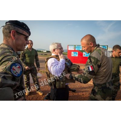 Monsieur Charles Malinas, ambassadeur de France en RCA, aidé par un légionnaire du 2e REI du GTIA (groupement tactique interarmes) Centurion, revêt un gilet pare-balles lors d'une visite officielle sur le camp M'Poko de Bangui.